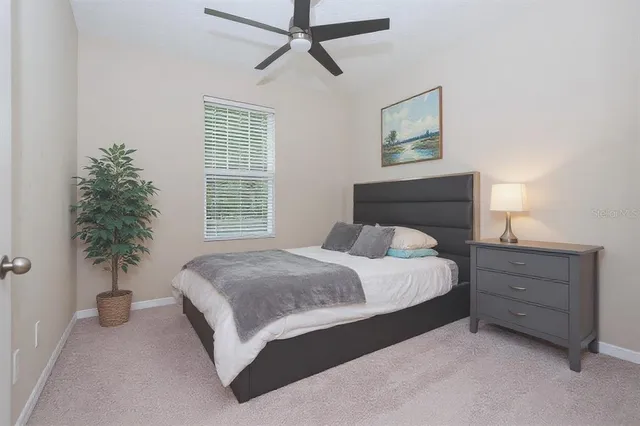 a bedroom with a bed and a potted plant