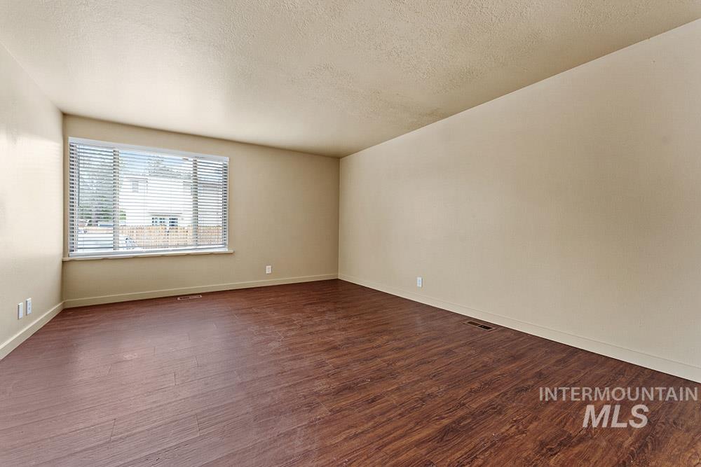 4806 Richardson Street Boise, ID 83705 - Photo 5 of 19 Spare room featuring a textured ceiling and dark wood finished floors