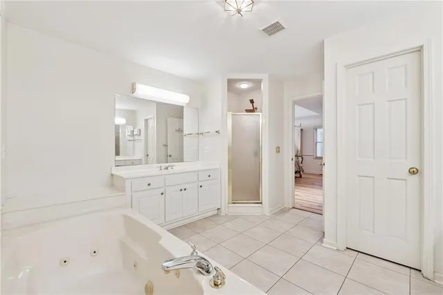 a spacious bathroom with a shower a sink and a mirror