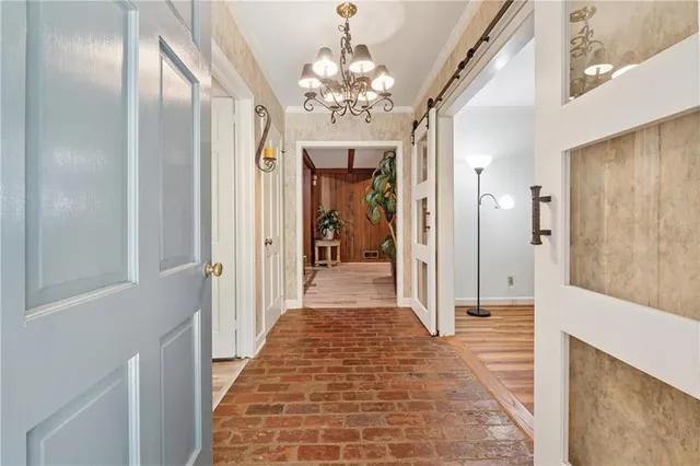a view of a hallway with a chandelier and dining room view