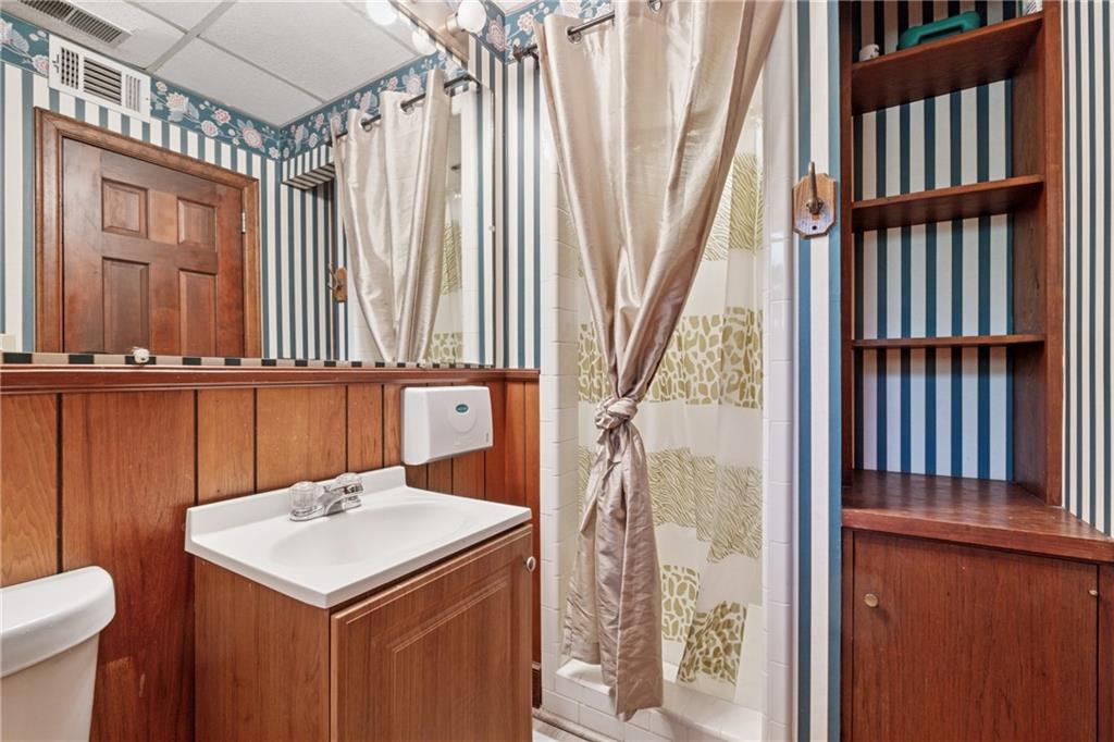 1387 Springdale Road Gainesville, GA 30501 - Photo 36 of 49 a bathroom with a sink a toilet and a shower curtain