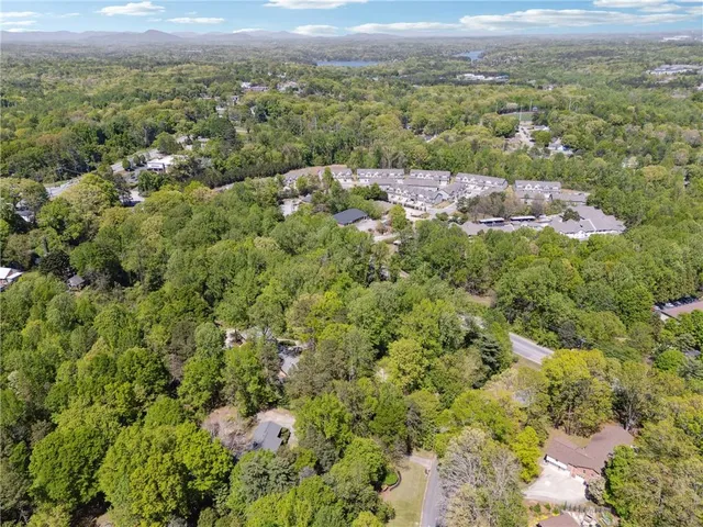 an aerial view of a houses with a yard and lake view