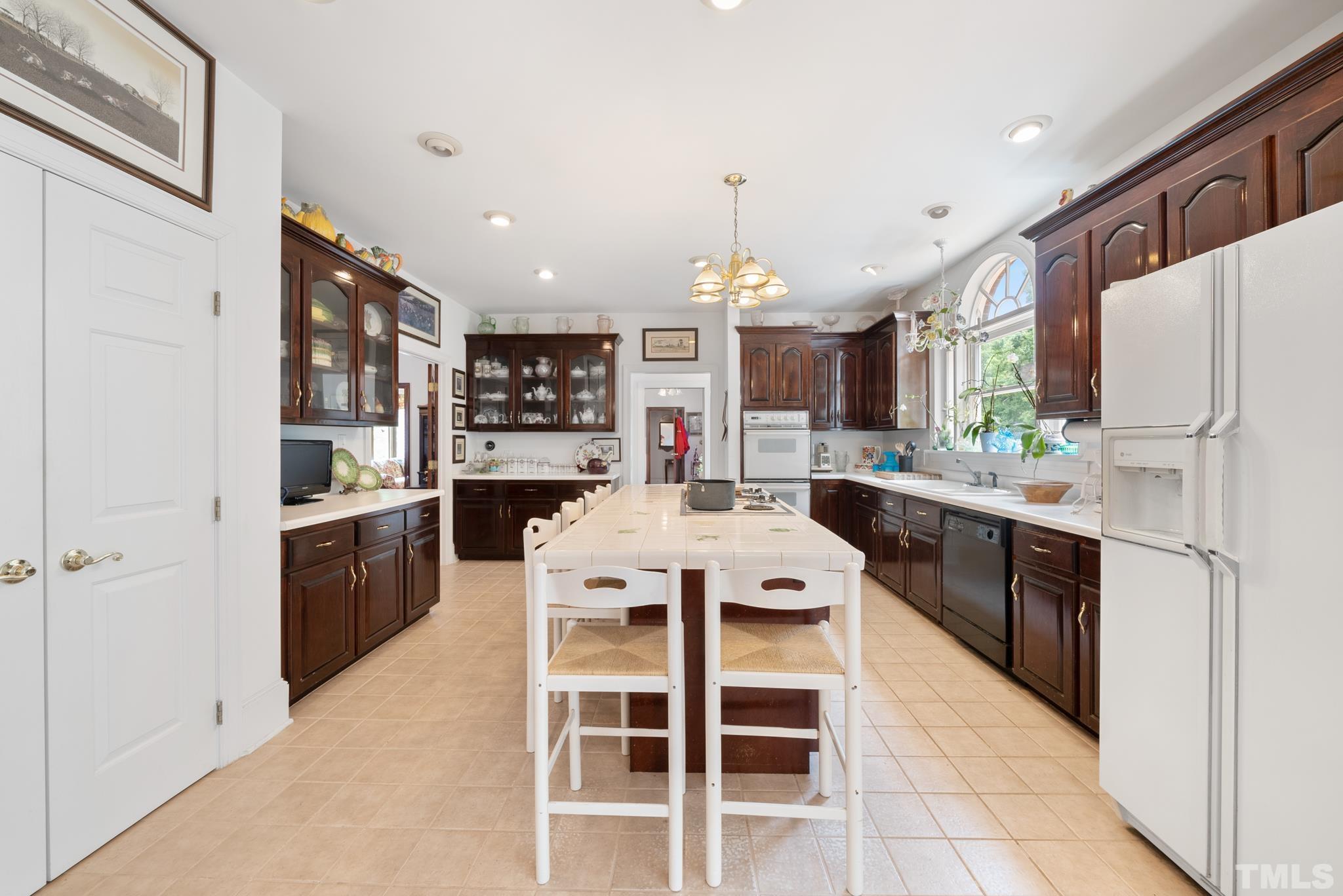 920 Windrow Lane Raleigh, NC 27603 - Photo 11 of 40 a kitchen with stainless steel appliances a stove a sink dishwasher a refrigerator and cabinets with wooden floor
