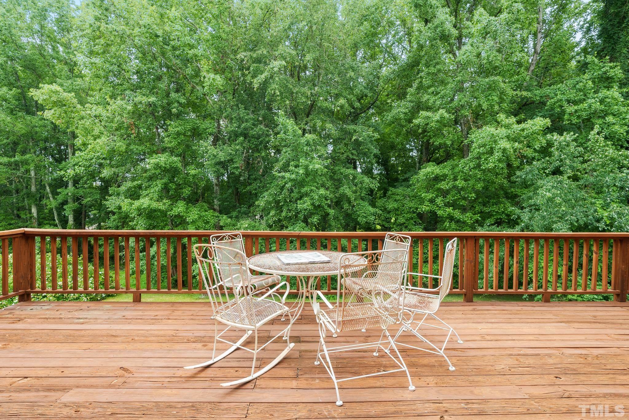 920 Windrow Lane Raleigh, NC 27603 - Photo 35 of 40 a view of a patio with a table and chairs a barbeque with wooden floor