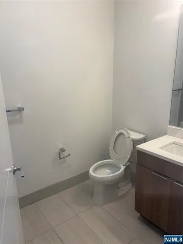 a bathroom with a granite countertop toilet and a sink