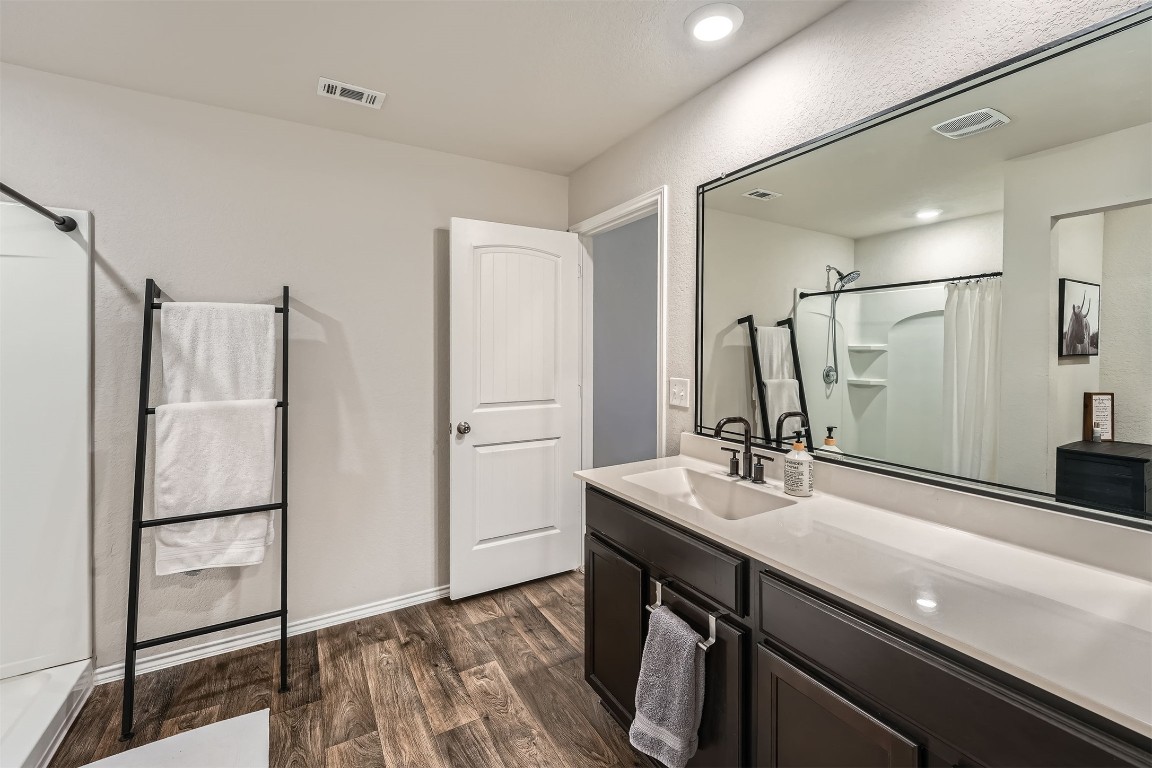 6404 Diamondleaf Bend Austin, TX 78724 - Photo 16 of 29 Bathroom with vanity, a shower with curtain, and dark wood-style floors