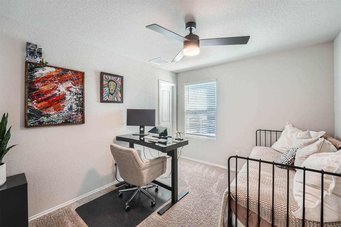 6404 Diamondleaf Bend Austin, TX 78724 - Photo 17 of 29 Carpeted bedroom with an office area, a ceiling fan, and a textured ceiling