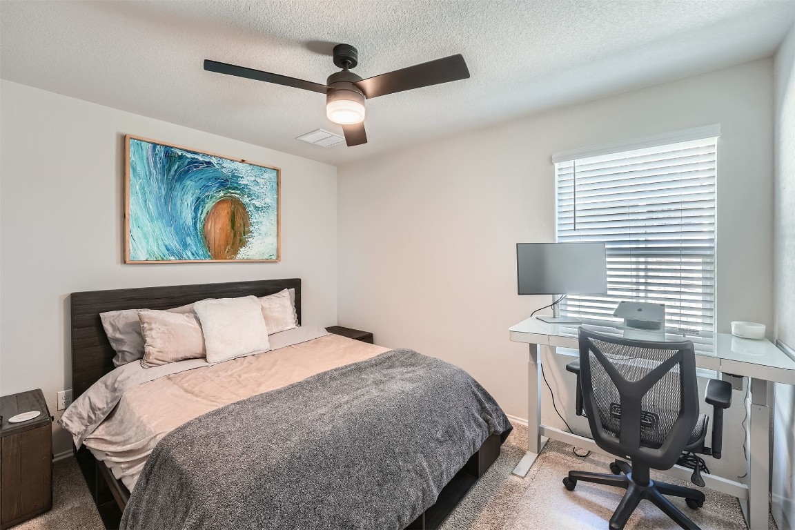 6404 Diamondleaf Bend Austin, TX 78724 - Photo 19 of 29 Bedroom with carpet, a ceiling fan, a textured ceiling, and an office area