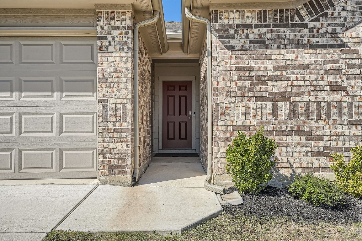 6404 Diamondleaf Bend Austin, TX 78724 - Photo 2 of 29 Property entrance with brick siding, a garage, and stone siding