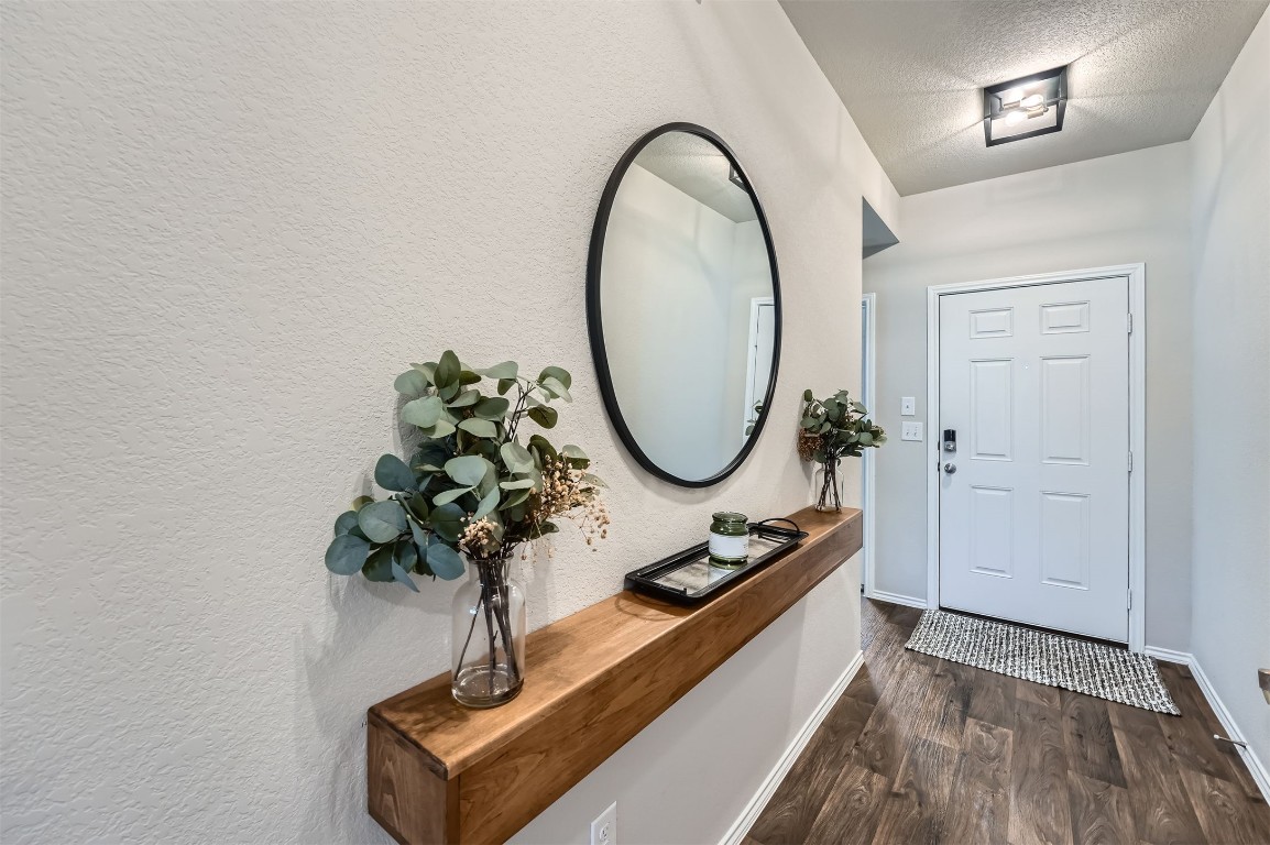 6404 Diamondleaf Bend Austin, TX 78724 - Photo 3 of 29 Foyer entrance featuring dark wood-style flooring and a textured ceiling
