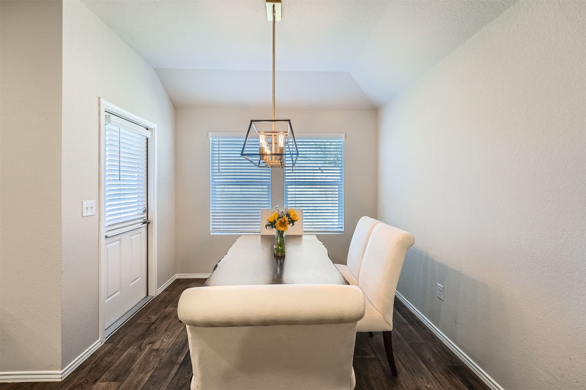 6404 Diamondleaf Bend Austin, TX 78724 - Photo 7 of 29 Dining space with dark wood-style flooring, vaulted ceiling, and a chandelier