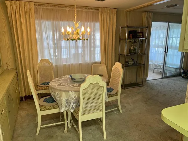 a dining room with furniture and chandelier kitchen view