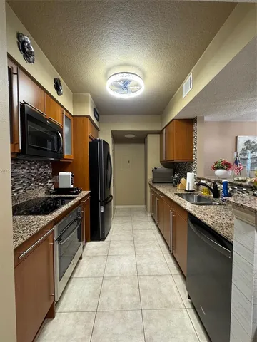 a large kitchen with stainless steel appliances granite countertop a stove and a sink
