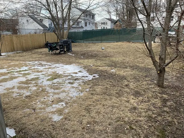 a view of backyard with table and chairs and a fire pit