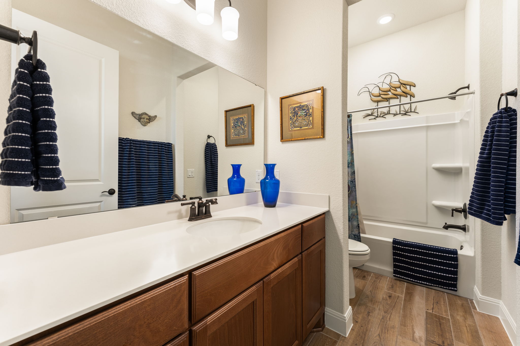 112 Telegraph Lane Georgetown, TX 78633 - Photo 17 of 35 Ensuite bathroom for guest bedroom #1. Features Miami White Quartz counters, American Beech-Chateau cabinets, and upgraded oil rubbed bronze Dartmoor faucet and oil rubbed bronze bath hardware and fixtures. There are also upgraded Aubrey Olde Bronze light fixtures.