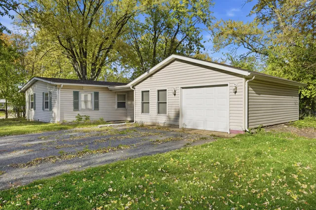a view of a yard with a house and a large tree
