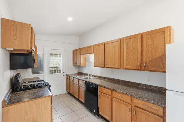 a kitchen with stainless steel appliances granite countertop a stove a sink and a microwave