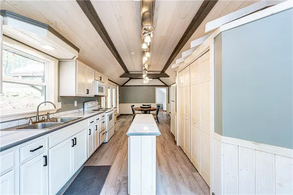 a view of a kitchen with a sink and wooden floor