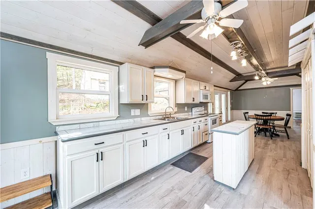 a kitchen with white cabinets and sink