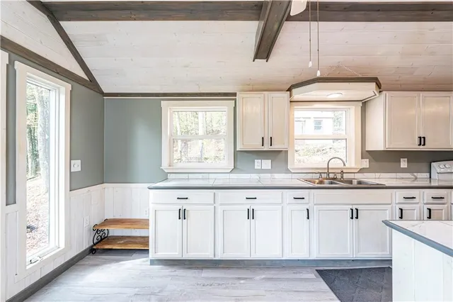a kitchen with granite countertop white cabinets and sink