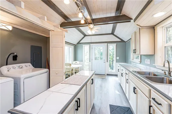 a large white kitchen with a large window