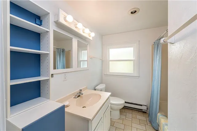 a bathroom with a sink toilet and a window