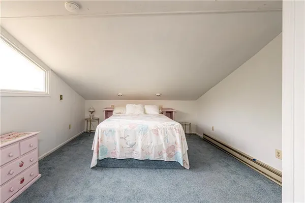 a bed sitting in a bedroom next to a window