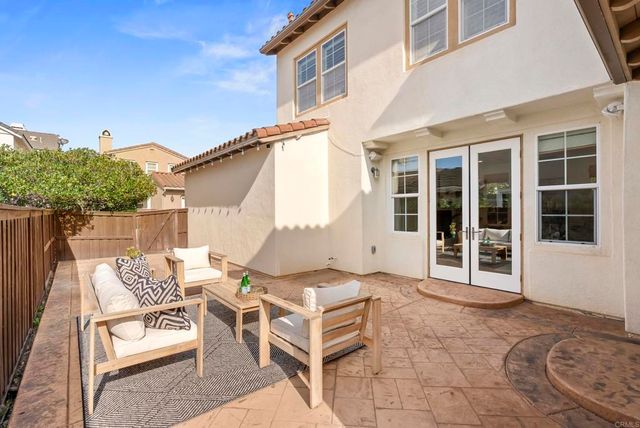 a view of a patio with a table and chairs and potted plants