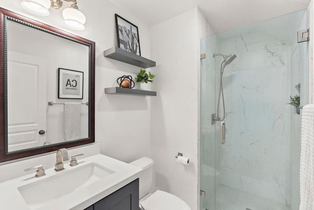 a bathroom with a sink vanity mirror and toilet