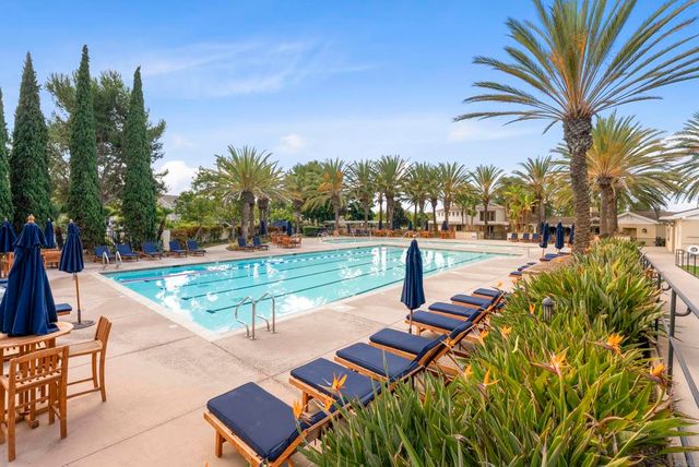 a view of a patio with table and chairs potted plants and large tree