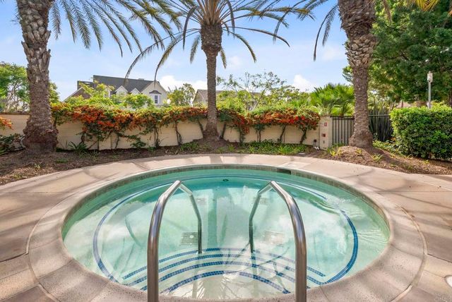 a view of a patio with table and chairs potted plants and floor to ceiling window