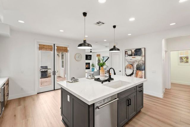 a kitchen with a sink appliances and wooden floor