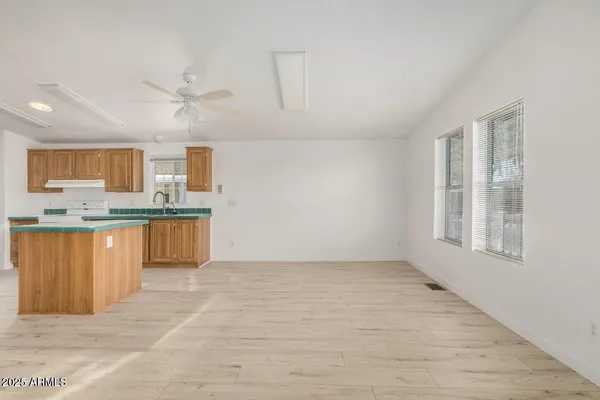a view of kitchen with granite countertop cabinets and window