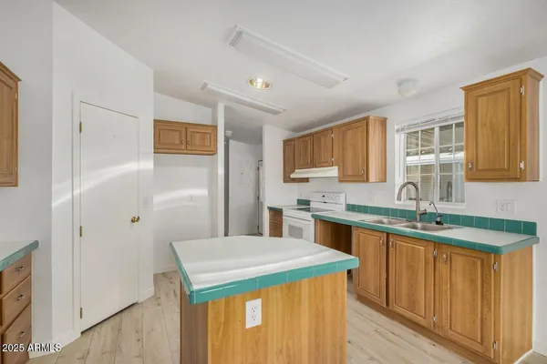 a kitchen with a sink a stove a refrigerator and a cabinets