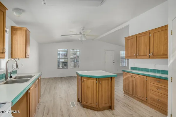 a kitchen with a sink a stove cabinets and wooden floor