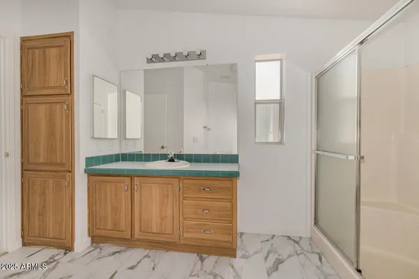 a bathroom with a granite countertop sink and a mirror