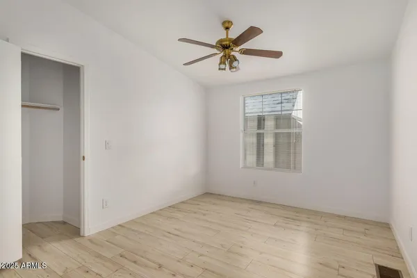 a view of a big room with wooden floor and windows