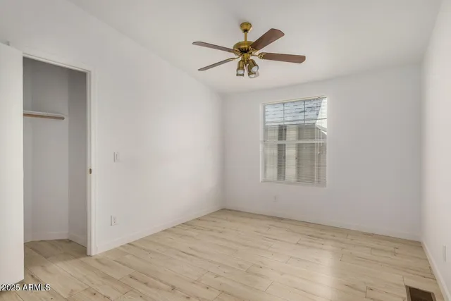 a view of a big room with wooden floor and windows