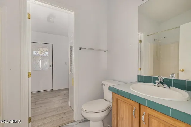 a bathroom with a granite countertop sink toilet and shower