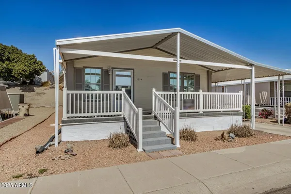 a view of a house with a small yard and wooden fence
