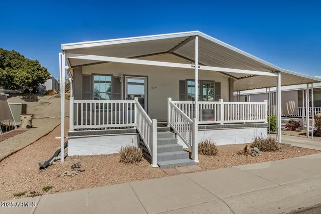 a view of a house with a small yard and wooden fence
