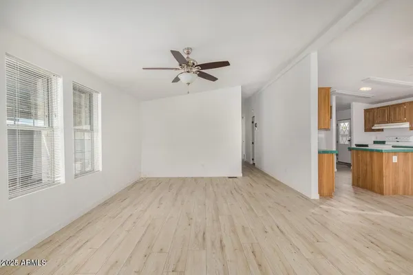 a view of empty room with wooden floor and window