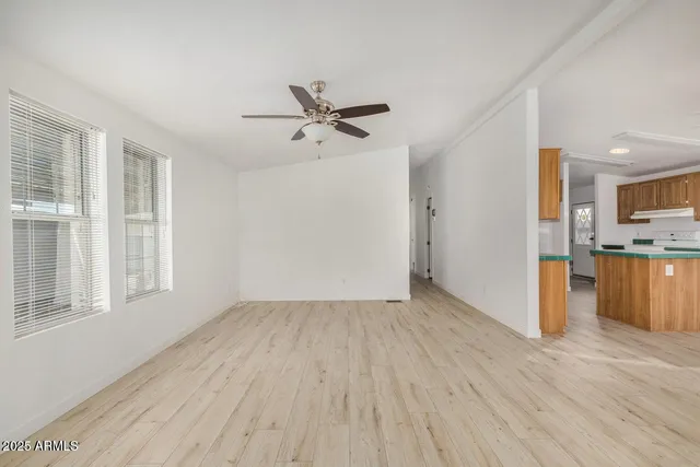 a view of empty room with wooden floor and window