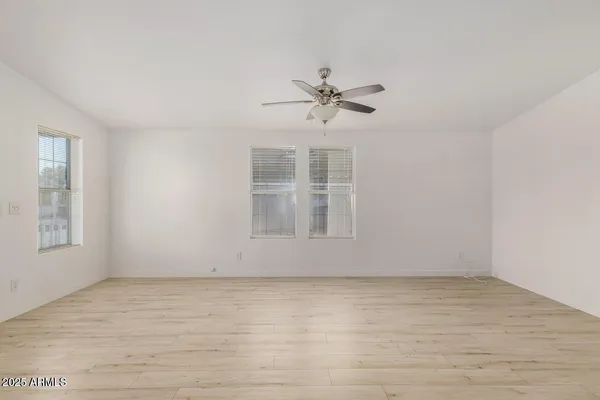 a view of room with hardwood floor and ceiling fan