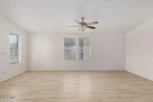 a view of room with hardwood floor and ceiling fan