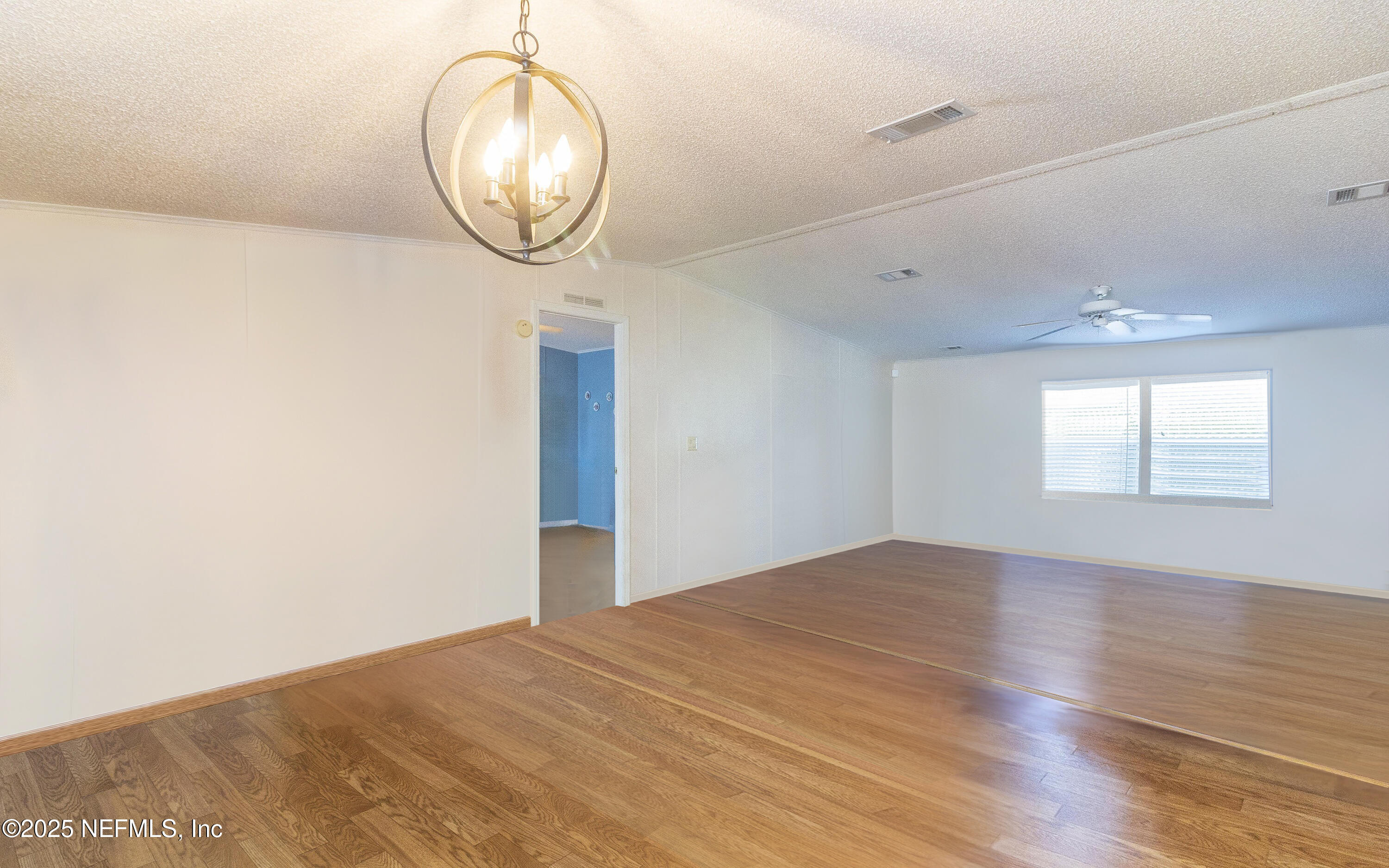 222 Kitty Avenue Interlachen, FL 32148 - Photo 12 of 34 an empty room with wooden floor and windows