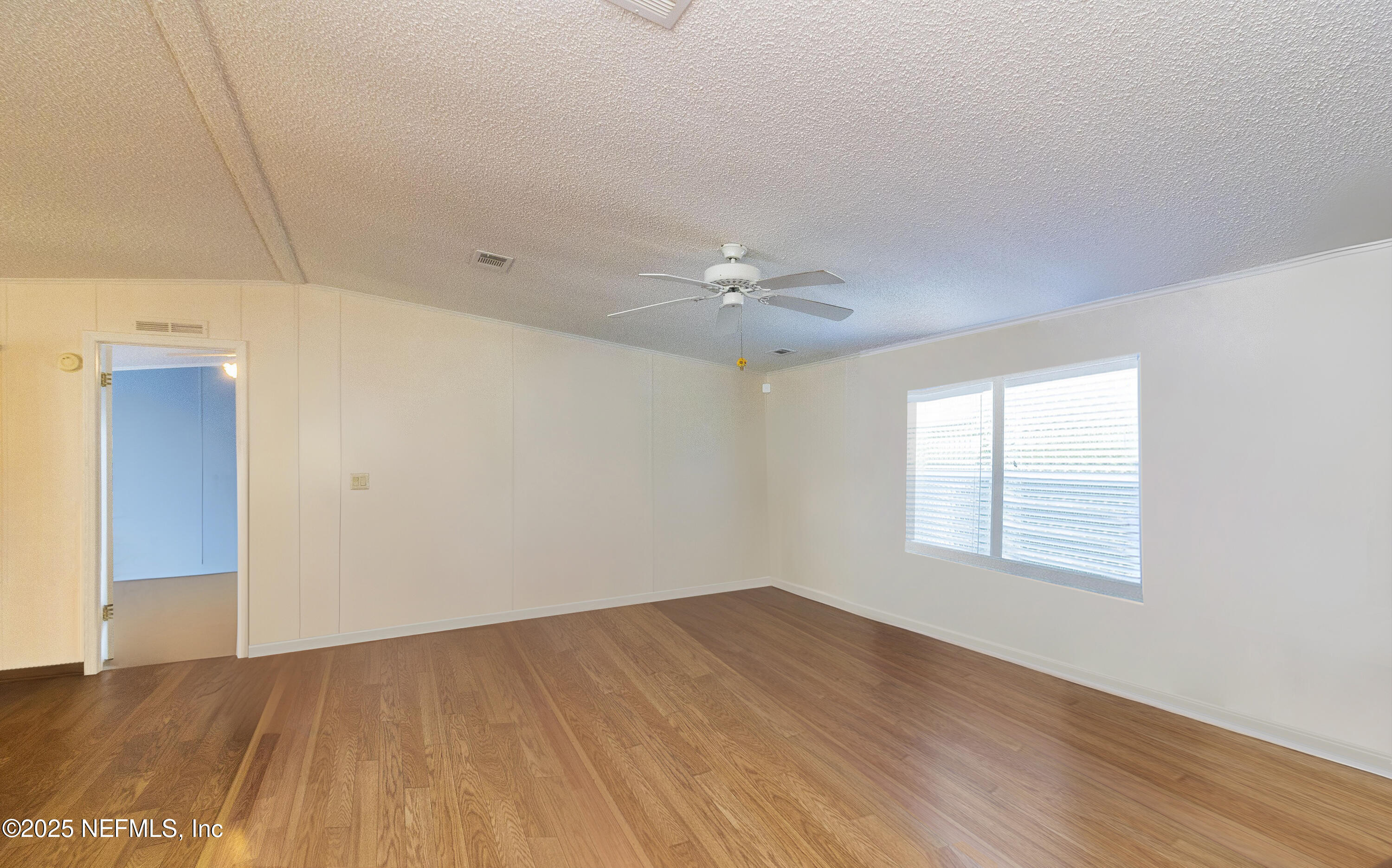 222 Kitty Avenue Interlachen, FL 32148 - Photo 13 of 34 a view of an empty room with wooden floor and a window
