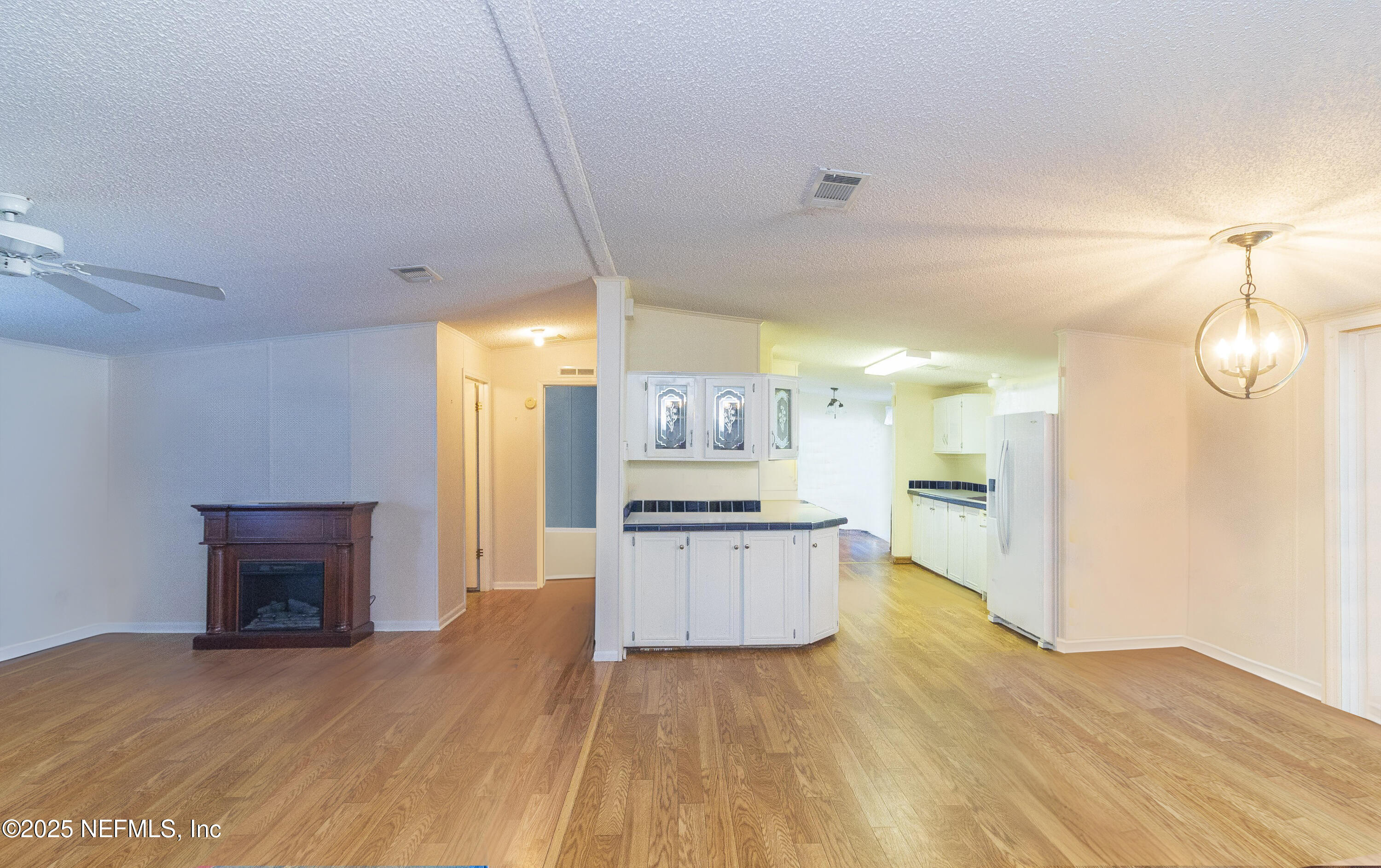222 Kitty Avenue Interlachen, FL 32148 - Photo 16 of 34 a open kitchen with granite countertop a stove top oven a sink dishwasher and a fireplace with wooden floor
