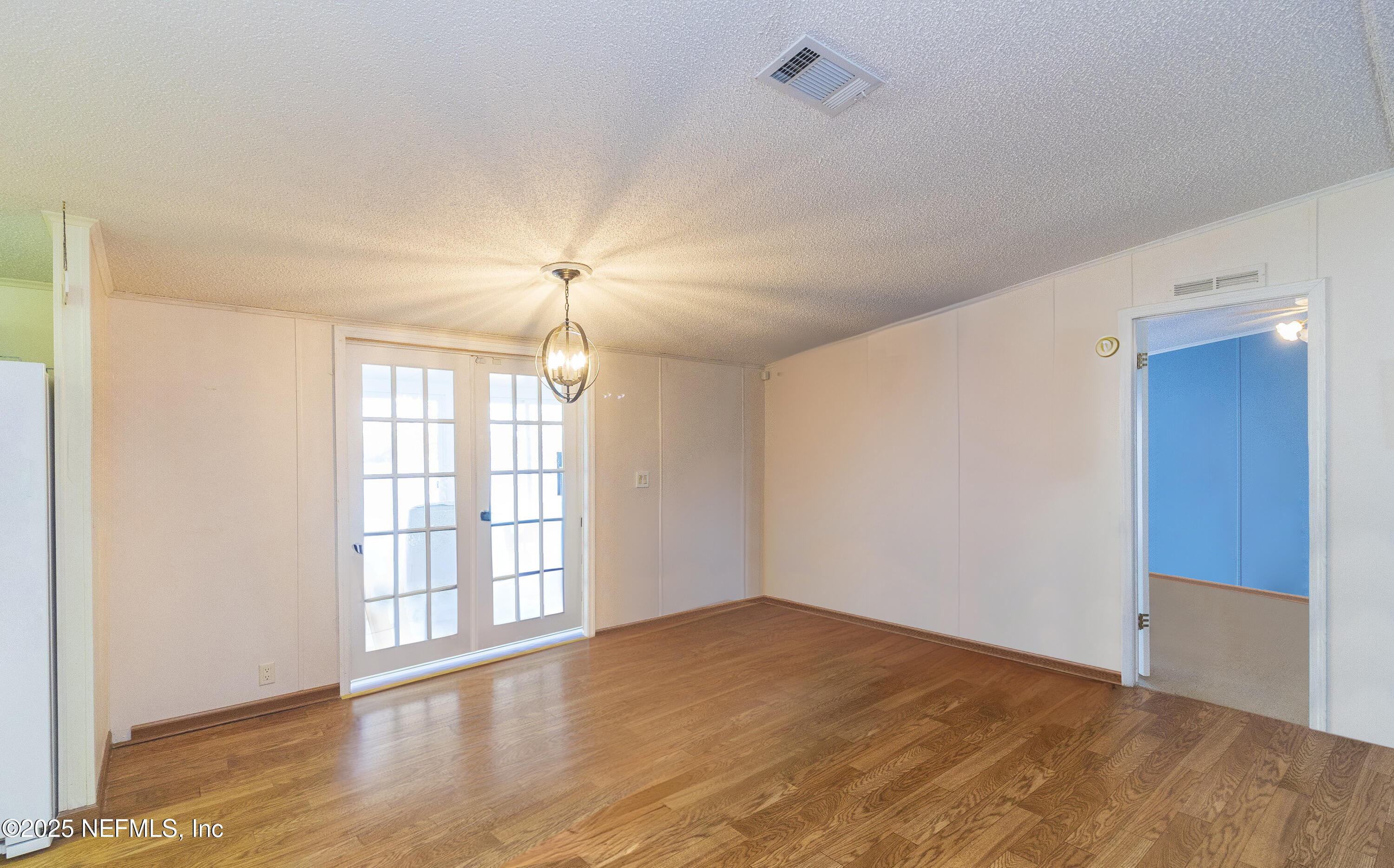 222 Kitty Avenue Interlachen, FL 32148 - Photo 21 of 34 a view of an empty room with wooden floor and a window