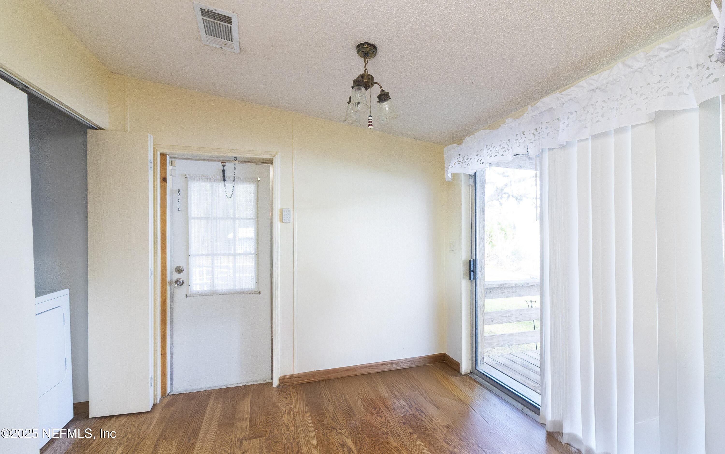 222 Kitty Avenue Interlachen, FL 32148 - Photo 22 of 34 a view of an empty room with wooden floor and a window